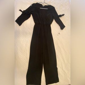 Black jumpsuit by Speechless. Split leg and open shoulder with cute elbow ties.